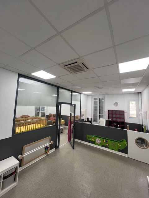 Couloir de creche renove avec plafond blanc et casiers de rangement rouges