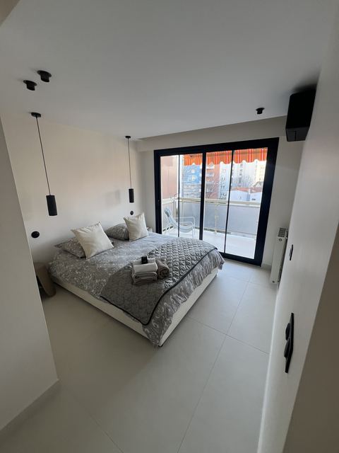 Chambre repeinte en blanc avec vue sur la ville, finition soignee
