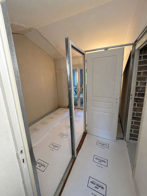 Couloir et porte d'entree en cours de renovation avec protection de sol, preparation avant peinture